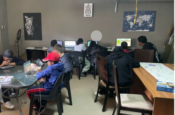 Students at the ICanLearnProgram centre working at computers and tables in one small room.