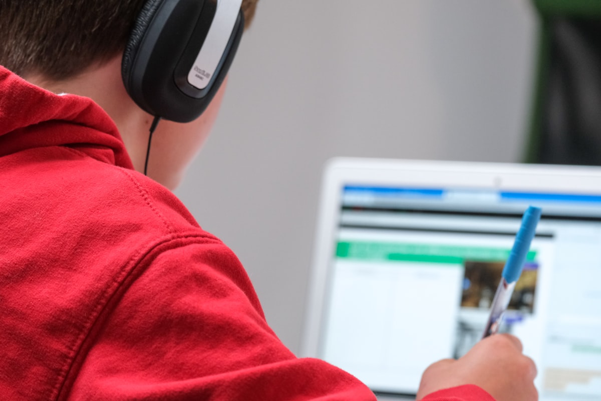 A student in headphones concentrating on a laptop at home.