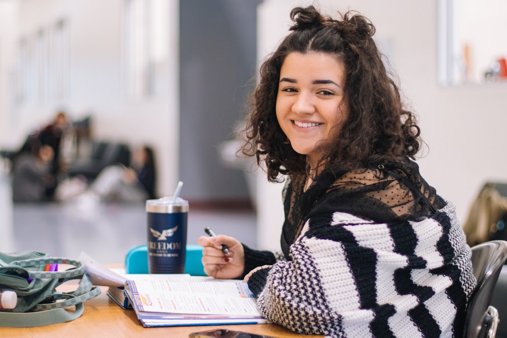 A student looking up from her work with a wide smile.